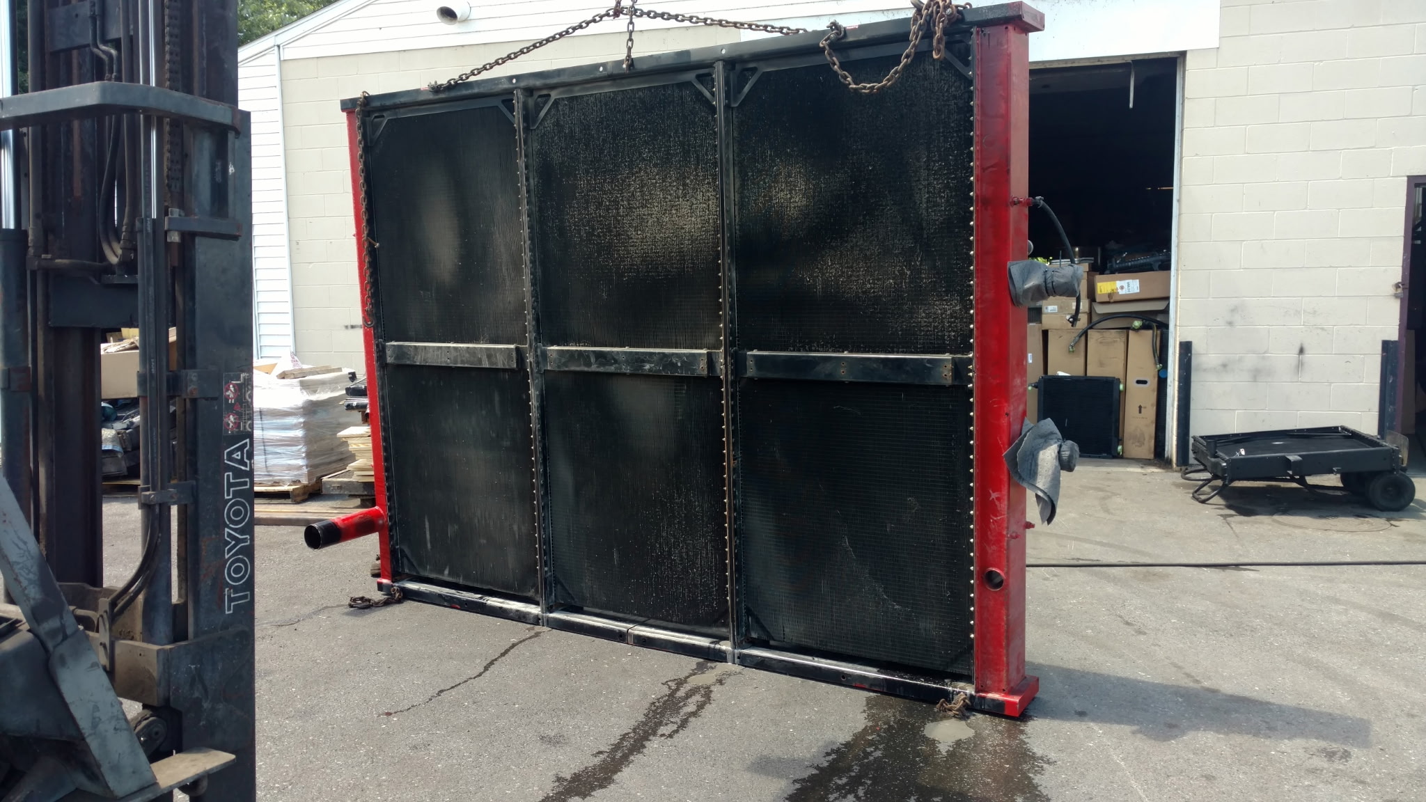 Large red-framed industrial radiator core on a forklift